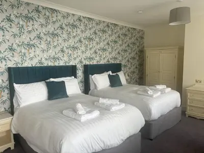 two beds sitting next to each other in a bedroom at Feathers Hotel Bar and Restaurant in Aberaeron