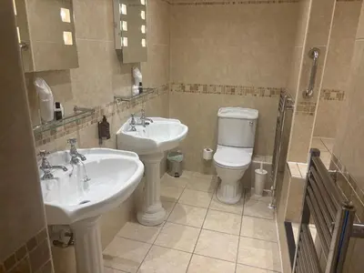 a bathroom with two sinks and a toilet at Feathers Hotel Bar and Restaurant in Aberaeron