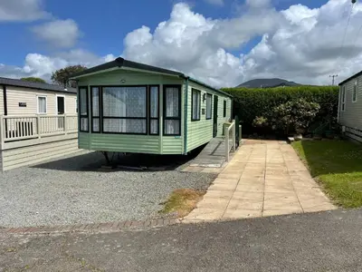 a green house is parked in a driveway at Kyffin 643 in Barmouth