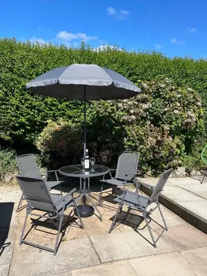 a table with two chairs and an umbrella at Kyffin 643 in Barmouth