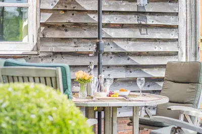 a table with glasses and flowers on a patio at 2 Bed in Little Hereford oc-l29580 in Berrington