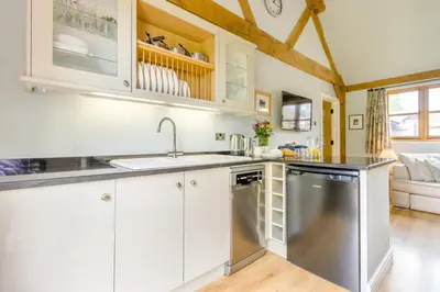 a kitchen with white cabinets and a stainless steel dishwasher at 2 Bed in Little Hereford oc-l29580 in Berrington