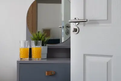two glasses of orange juice sitting on a table in front of a mirror at Eryri Snowdonia Premier Family Retreat with Hot Tub and Fire Pit in Dolgellau