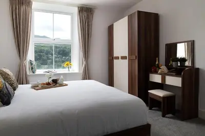 a bedroom with a large white bed and a window at Eryri Snowdonia Premier Family Retreat with Hot Tub and Fire Pit in Dolgellau