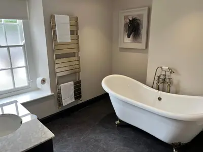 a white bath tub in a bathroom with a window at The Castle Coaching Inn in Trecastle