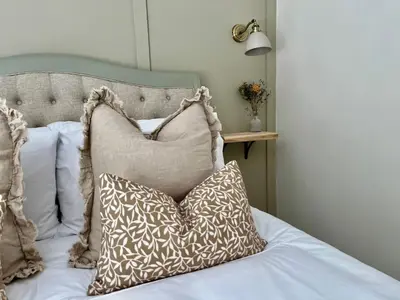 a bed with pillows on top of it at Posh Little Cottage in Llangollen