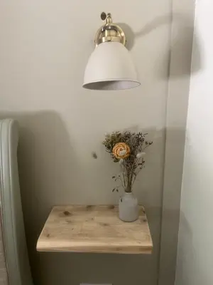 a table with a lamp and a vase with flowers on it at Posh Little Cottage in Llangollen