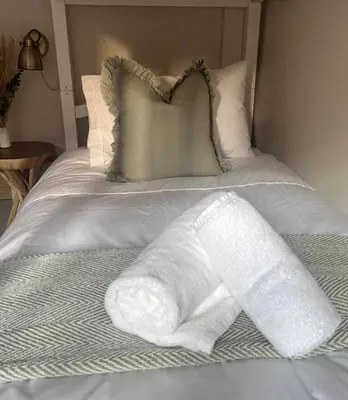 a bed with white towels on top of it at Posh Little Cottage in Llangollen