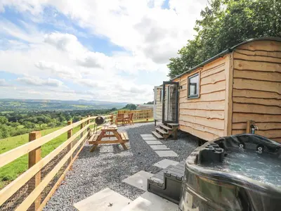 a cabin with a picnic table and a wooden fence at Shepherd's Cwtch in Llandovery