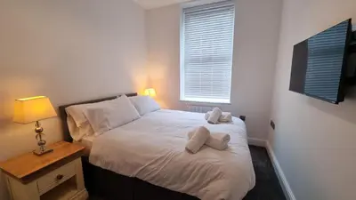 a bedroom with a bed with two towels on it at Abergwaun APT 1 in Aberystwyth