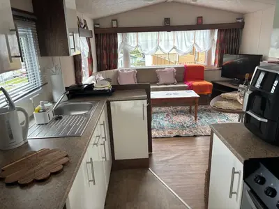 a kitchen and living room with a couch at Stunning Pet Friendly 2 bed StaticCaravan in Clarach Bay 2017 model in Aberystwyth