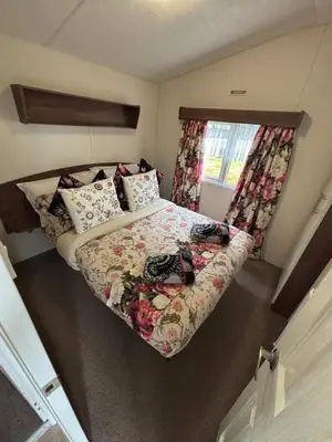a small bed in a small room with a window at Stunning Pet Friendly 2 bed StaticCaravan in Clarach Bay 2017 model in Aberystwyth