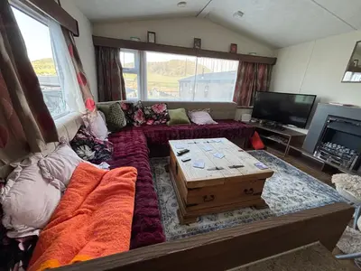 a living room with a couch and a coffee table at Stunning Pet Friendly 2 bed StaticCaravan in Clarach Bay 2017 model in Aberystwyth
