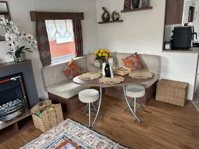a living room with a table and a couch at Stunning Pet Friendly 2 bed StaticCaravan in Clarach Bay 2017 model in Aberystwyth