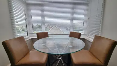 a dining room with a glass table and two chairs at Abergwaun Apt 2 in Aberystwyth