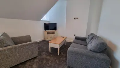 a living room with two couches and a tv at Abergwaun Apt 3 in Aberystwyth