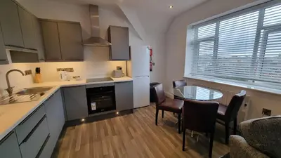 a kitchen with a table and chairs and a refrigerator at Abergwaun Apt 3 in Aberystwyth