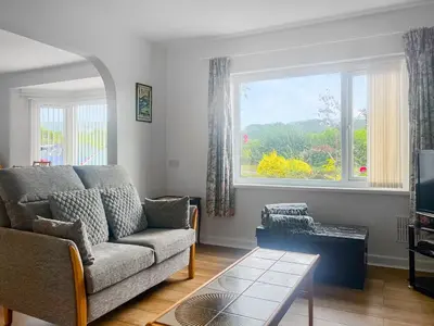 a living room with a couch and a large window at Mum's Place in Hay-on-Wye