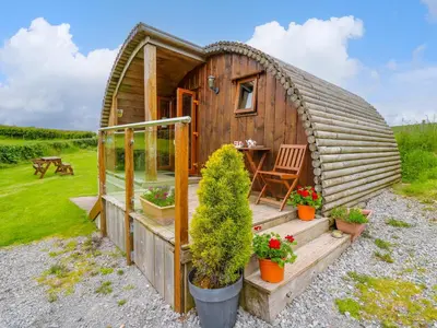 a small wooden house with a table and a chair at Oak View in Llangadog