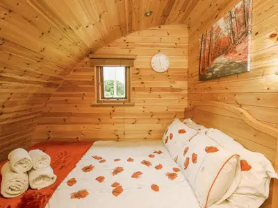 a bedroom with a bed in a log cabin at Oak View in Llangadog