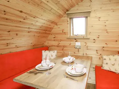 a dining room with a table and chairs in a log cabin at Oak View in Llangadog