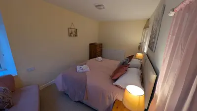 a bedroom with a bed with two pillows and two lamps at Synod Farm Cottage, 5 Person Hot Tub, Pets Welcome in Llandysul