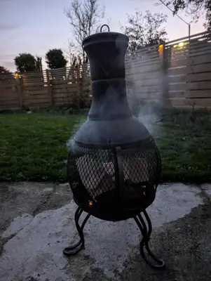 a black vase sitting on the ground in a yard at Synod Farm Cottage, 5 Person Hot Tub, Pets Welcome in Llandysul