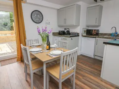 a kitchen and dining room with a table and chairs at Garden View in Llanybydder
