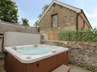 a hot tub in front of a building at Garden View in Llanybydder