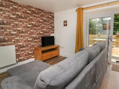 a living room with a couch and a tv at Garden View in Llanybydder