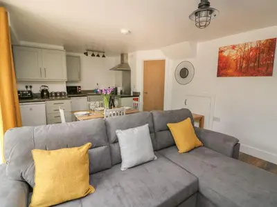a living room with a gray couch with yellow pillows at Garden View in Llanybydder