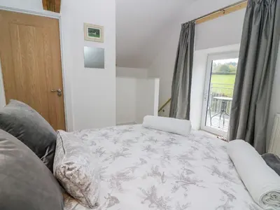a bedroom with a bed and a window at Field View in Llanybydder