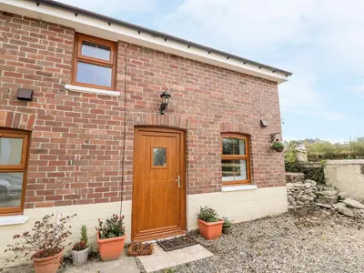 a brick house with a wooden door at Field View in Llanybydder