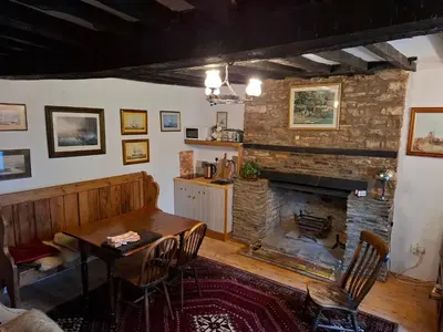 a living room with a table and a fireplace at Ty Gwyn Farmhouse in Brecon