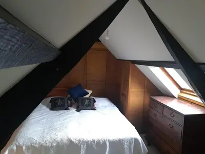 a bedroom with a white bed in a attic at Ty Gwyn Farmhouse in Brecon