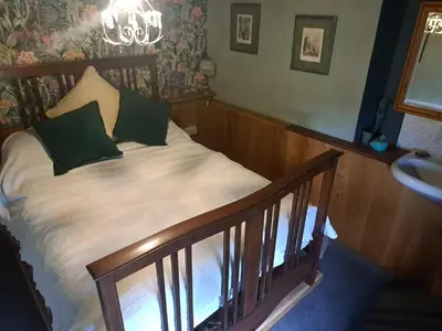 a bed with green pillows on top of a staircase at Ty Gwyn Farmhouse in Brecon