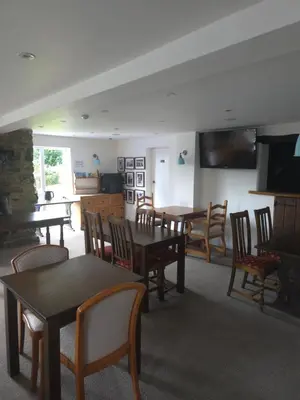 a dining room with tables and chairs and a television at The Royal Oak Inn, Rhandirmwyn in Rhandirmwyn
