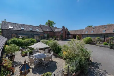an overhead view of a house with a patio with an umbrella at Daisys Place at Middle Farm and Cottages in Picklescott