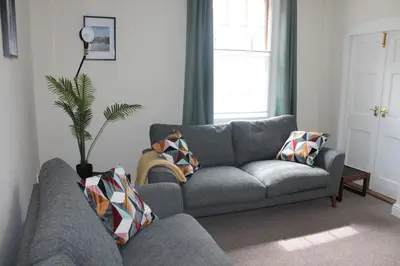 a living room with a gray couch and a window at Shrewsbury Georgian town house - Hills Lane in Shrewsbury