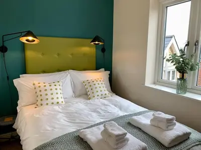 a bedroom with a white bed with towels on it at The Stokesay Ludlow in Ludlow