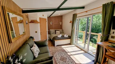 a small living room with a couch and a bed at The Duck House in Barmouth