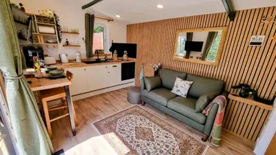 a living room with a couch and a kitchen at The Duck House in Barmouth