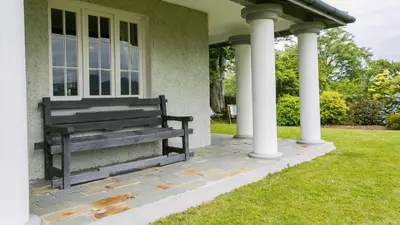 a bench sitting on the porch of a house at Hafod Cae Maen in Penrhyndeudreath