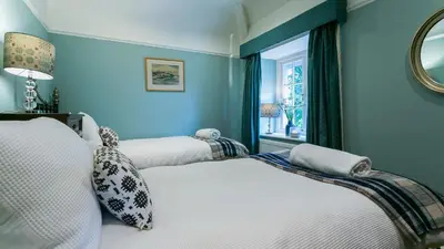 a blue bedroom with two beds and a window at Hafod Cae Maen in Penrhyndeudreath