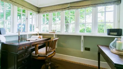 an office with a desk with a chair and windows at Hafod Cae Maen in Penrhyndeudreath