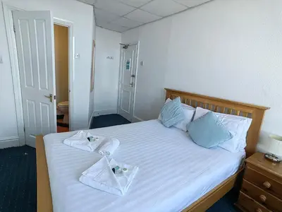 a bedroom with a bed with towels on it at Cardigan and Celtic Bay Guest House - Self Catering Accommodation in Aberystwyth