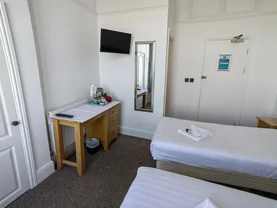 a room with two beds and a desk and a mirror at Cardigan and Celtic Bay Guest House - Self Catering Accommodation in Aberystwyth