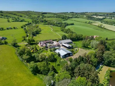 an aerial view of a house in a field at Gooseyard at Middle Farm and Cottages in Picklescott