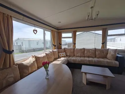 a living room with a couch and a table at Snowdonia Holiday Sea Beach and Mountains view in Llwyngwril