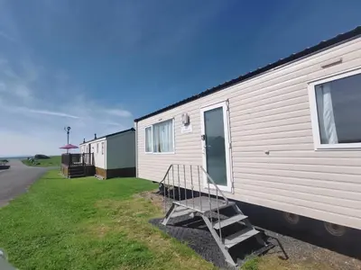 a mobile home with a staircase on the side of it at Snowdonia Holiday Sea Beach and Mountains view in Llwyngwril